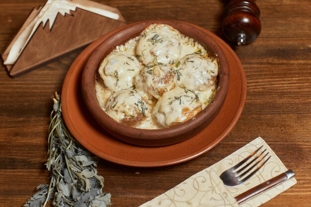 Cozinha georgiana. Cogumelos de cogumelos cozidos com carne, queijo, salsa e romã. Servindo em um restaurante em uma panela de ferro. imagem de fundo, copie o espaço.