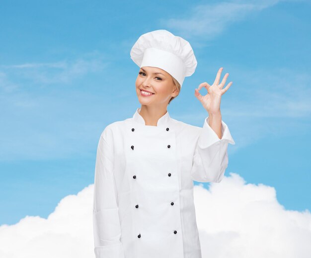 cozinha, gesto e conceito de comida - chef feminina sorridente mostrando sinal de mão ok