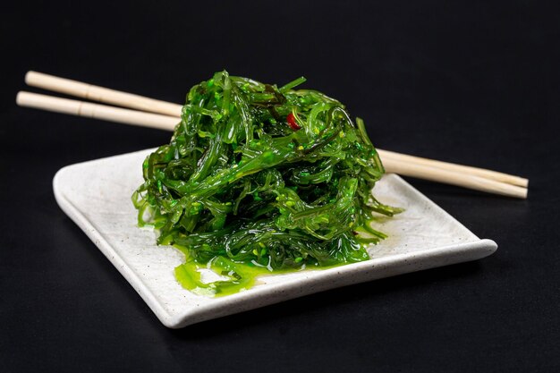Cozinha japonesa salada de algas chuka servida com molho de nozes e gergelim