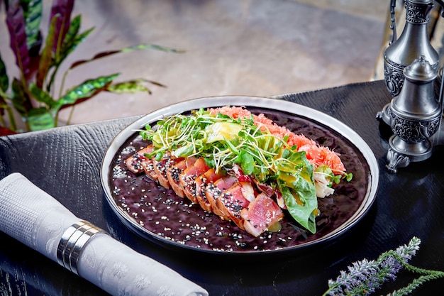 Cozinha moderna. Carne assada rara com folhas verdes de salada e toranja. Salada quente para o almoço. Comida saudável. Carne assada. Fechar-se. Horizontal. Copie o espaço