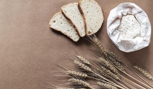 Cozinha rústica ou fundo de padaria com pão de farinha e espigas de trigo