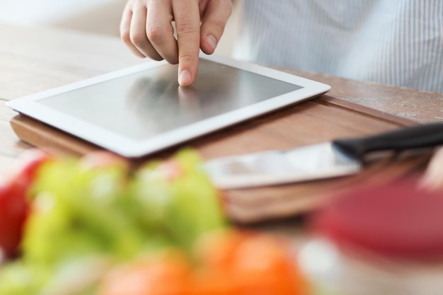 cozinha, tecnologia e conceito de casa - closeup do homem apontando o dedo para o computador tablet pc