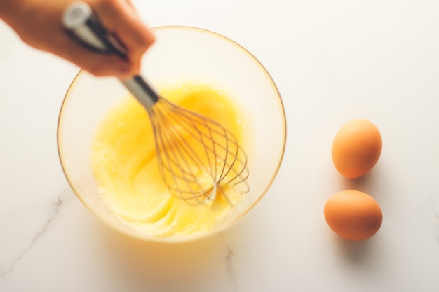 Cozinhando a refeição e o conceito de dieta fazendo misturas de ovos em uma tigela na mesa de mármore como comida caseira plana lay top view fotografia de marca de alimentos flatlay e receita para cozinhar menu de blog ou design de livro de receitas