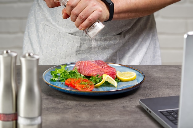 Cozinhando com bife de atum em casa cozinha on-line receita de culinária conceito de peixe cozinhando em casa