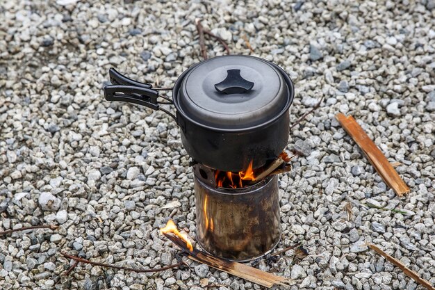 Cozinhando em um pequeno fogão de acampamento em um acampamento de montanha.