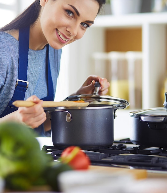 Cozinhando mulher na cozinha com colher de pau