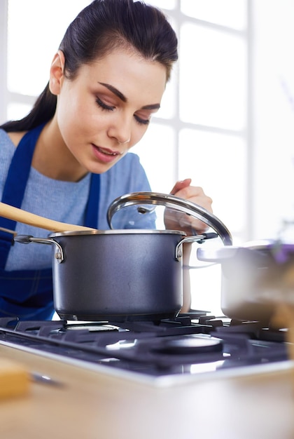 Cozinhando mulher na cozinha com colher de pau