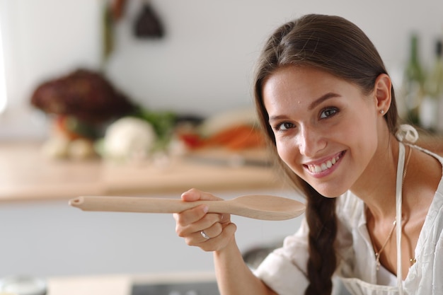 Cozinhando mulher na cozinha com colher de pau