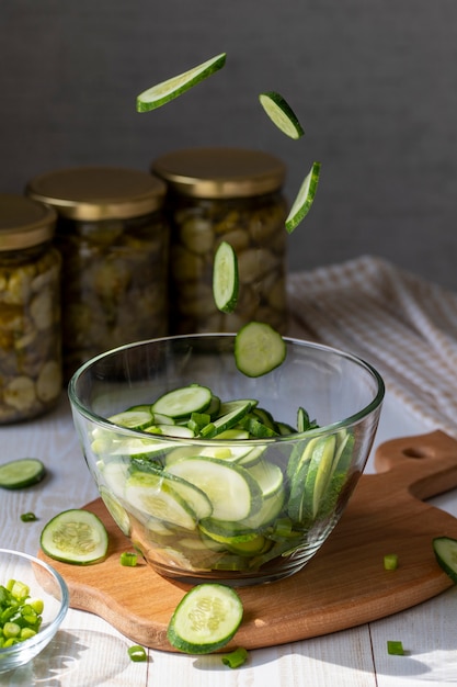 Cozinhando salada com pepinos frescos Voando fatias de pepino em um prato de vidro para salada