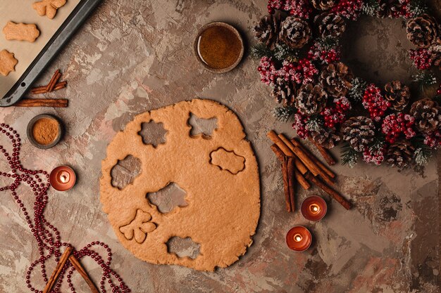 Cozinhar biscoitos de gengibre de ano novo. árvore de natal na mesa com velas.