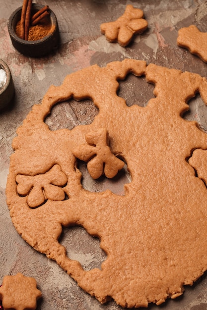 Cozinhar biscoitos de gengibre de ano novo. Árvore de Natal na mesa com velas.