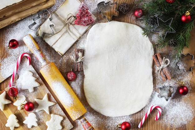 Cozinhar biscoitos de manteiga de diferentes formatos em uma mesa de madeira com acessórios de Natal