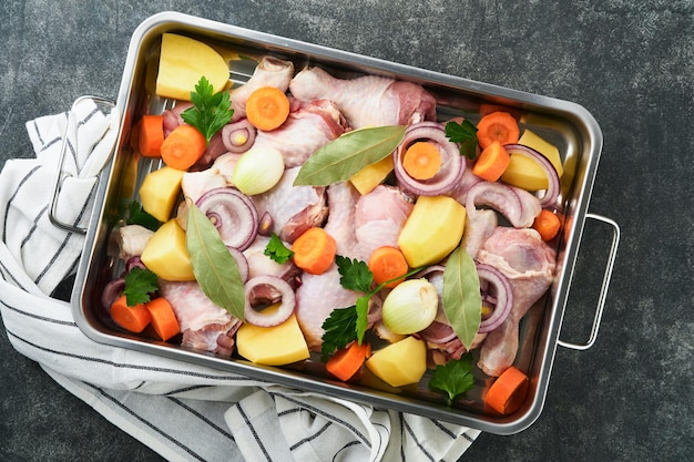 Cozinhar caldo de galinha ou assado em panela ou panela com legumes batatas cenouras e ervas na cozinha cinza cenário de bancada de concreto de cima Cozinhar preparando caldo de galinha Mock up