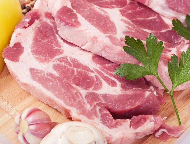 Foto cozinhar carne de porco com legumes na tábua de madeira