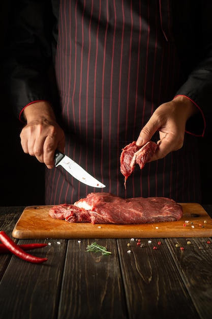 Cozinhar carne fresca pelas mãos do chef na cozinha Ideia de receita para um menu para um restaurante ou hotel