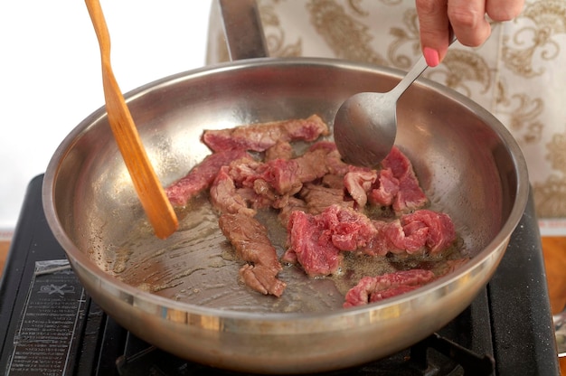 cozinhar carne frita em panela de metal