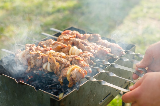 cozinhar carne na grelha em um piquenique Carne na grelha em um piquenique de verão