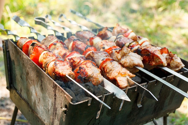 Foto cozinhar churrasco com legumes em espetos carne assada na grelha close-up