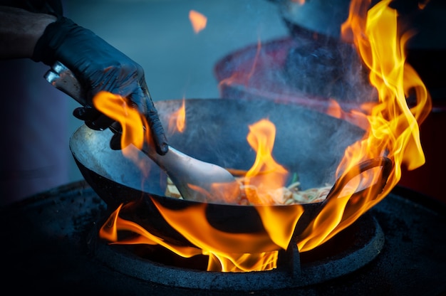 Cozinhar comida de rua em uma frigideira quente