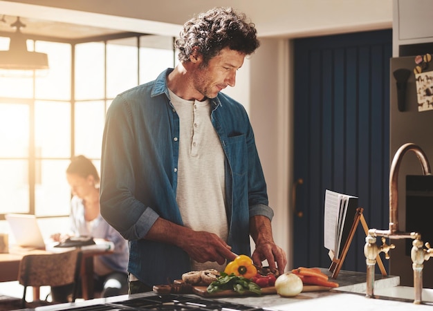 Foto cozinhar comida e homem cortar legumes na cozinha para uma dieta saudável ou nutrição jantar livro de receitas e homem maduro do canadá cortar ingredientes para uma ceia ou almoço em casa