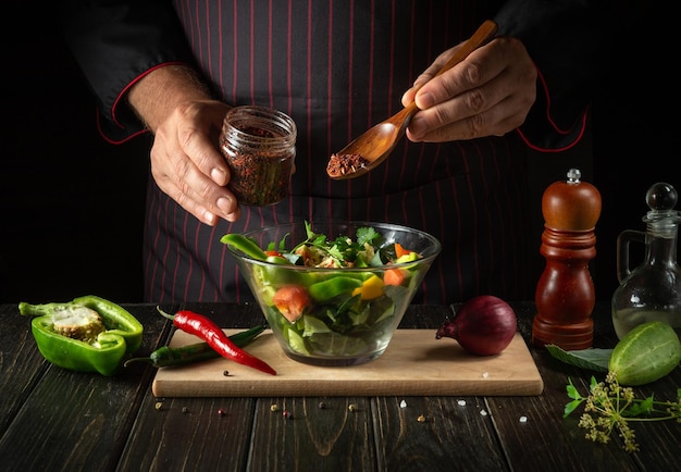 Cozinhar deliciosa salada pelas mãos do chef na cozinha