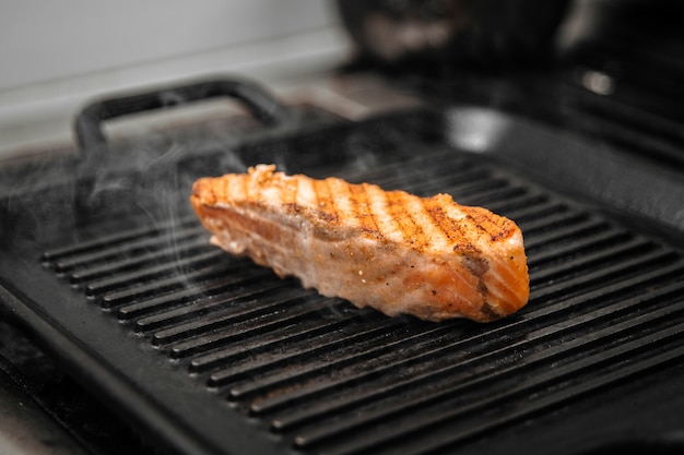 Cozinhar filé de salmão na grelha com fumo