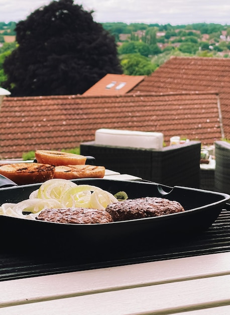 Cozinhar hambúrguer de carne picada na frigideira de ferro fundido ao ar livre carne vermelha na frigideira grelhar alimentos no jardim Vida rural inglesa