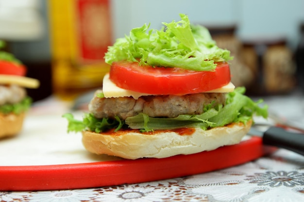 Foto cozinhar hambúrguer na cozinha de casa closeup delicioso hambúrguer de frango grelhado com queijo tomate e alface