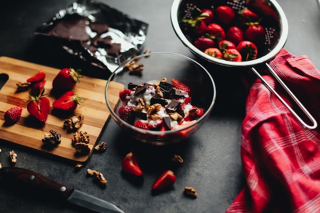 Cozinhar ingredientes, morango, chocolate, nozes em cima da mesa. Foto de alta qualidade