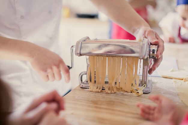 cozinhar macarrão italiano fresco com as próprias mãos em uma máquina de macarrão.