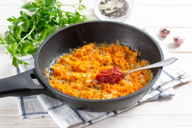 Cozinhar molho de vegetais com pasta de tomate para sopa na mesa. Passo a passo, receita.