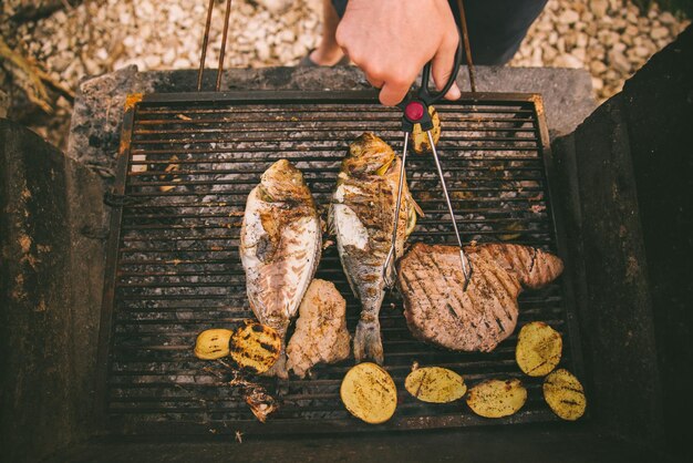 Cozinhar peixe e batatas na grelha