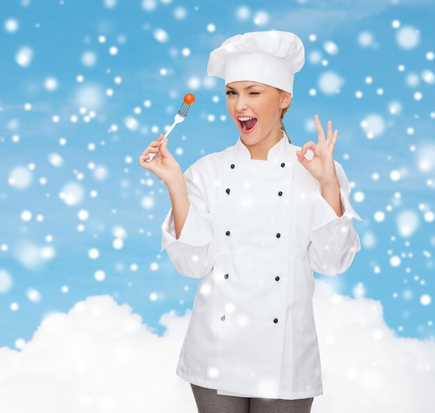 cozinhar, pessoas, feriados e conceito de comida - chef feminino sorridente ou cozinheiro com garfo mostrando o gesto okey sobre o céu azul nevado e o fundo da nuvem