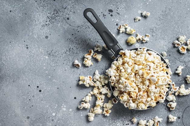 Cozinhar pipoca salgada em uma frigideira Fundo cinza Vista superior Copiar espaço