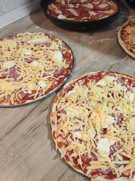 Cozinhar pizzas caseiras na mesa da cozinha em casa