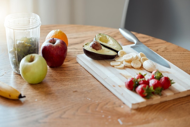 Cozinhar preparar e fazer suco de frutas e salada na cozinha de casa para uma refeição e lanche saudáveis de café da manhã Closeup de maçãs, morangos e abacate com banana para vitaminas e nutrição