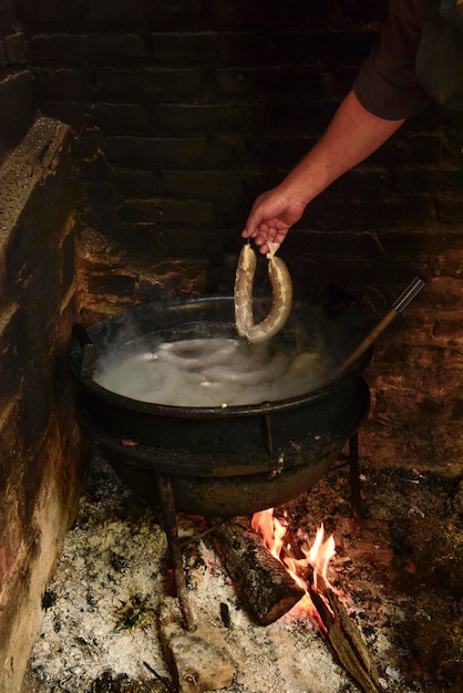 Cozinhar salsicha de sangue branco em uma panela de ferro em um fogão