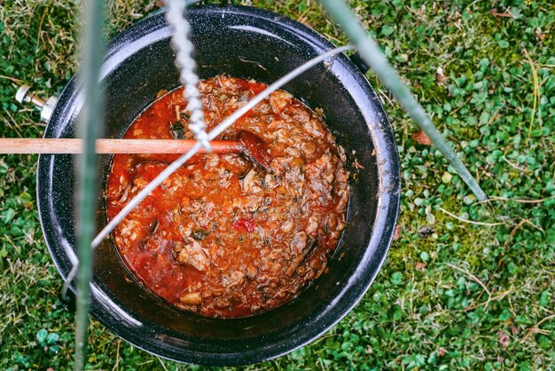 Cozinhar sopa de goulash de carne em um caldeirão Cozinhar em um ambiente natural em uma panela em fogo aberto