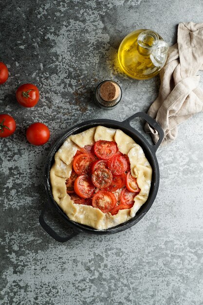 Cozinhar torta de massa com queijo feta e tomate, azeite e temperos