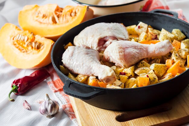 Foto cozinhar uma refeição de panela única - coxas de frango e pernas com batatas e abóbora