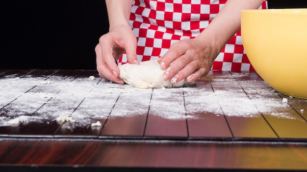 Cozinhe a preparar massa para assar na cozinha