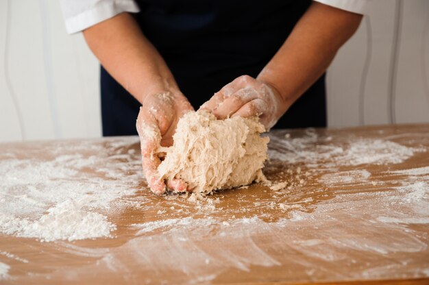 Cozinhe as mãos amassar massa, polvilhe um pedaço de massa com farinha de trigo branca.