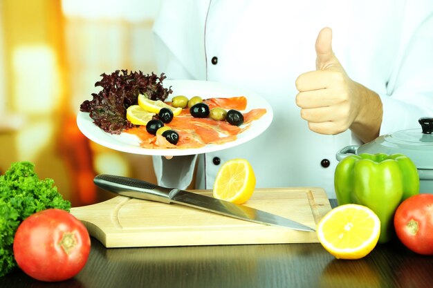 Foto cozinhe as mãos segurando o prato