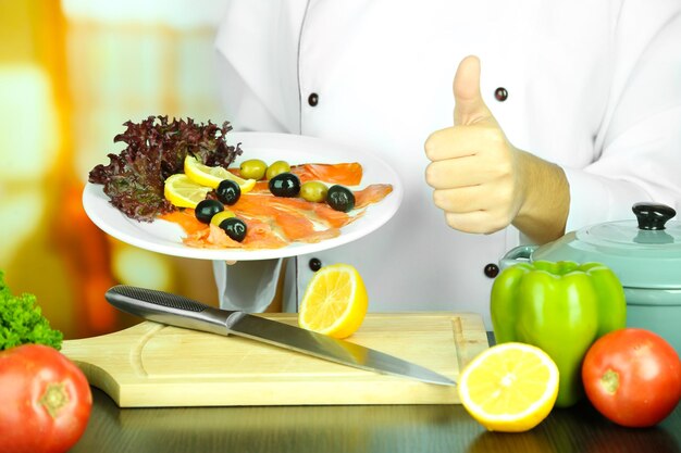 Foto cozinhe as mãos segurando o prato