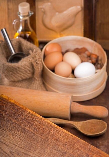 Cozinhe em casa Colheres de madeira espátulas utensílios de cozinha em uma mesa de madeira Produtos simples farinha e ovos na mesa de madeira