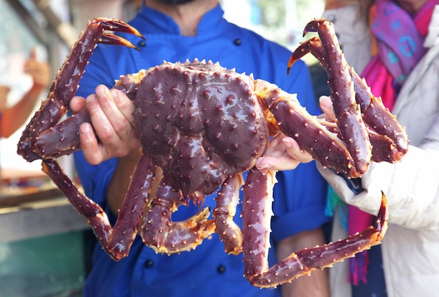 Cozinhe segurando um caranguejo grande