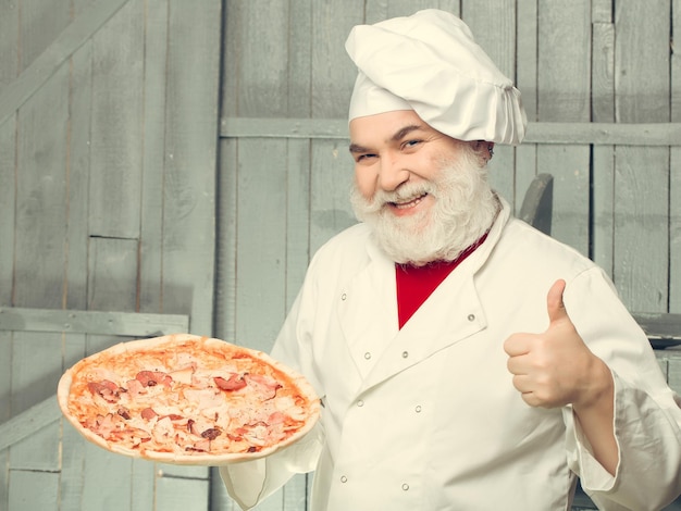 Foto cozinheiro barbudo com pizza