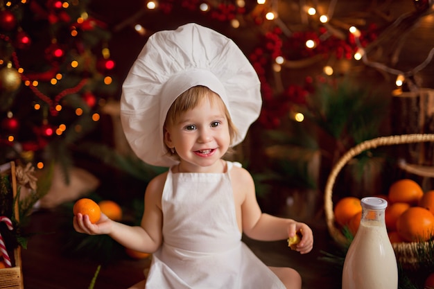 Cozinheiro de bebê preparando biscoitos de gengibre. feliz natal, tangerinas, árvore de natal