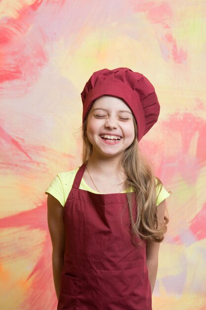 Cozinheiro de criança sorrindo na parede colorida