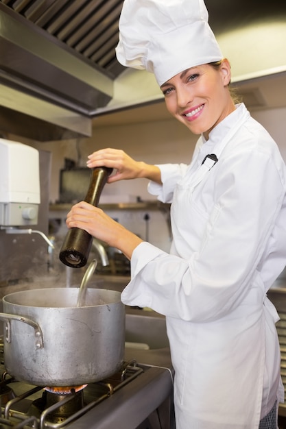 Cozinheiro feminino sorrindo preparando comida na cozinha